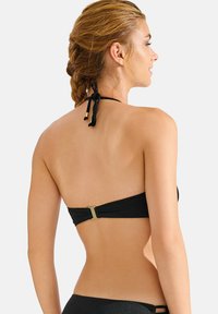Zwarte bikini top met een strapless ontwerp, voorzien van een goudkleurige sluiting aan de achterkant en een striksluiting achter de hals. Glad textuur.
