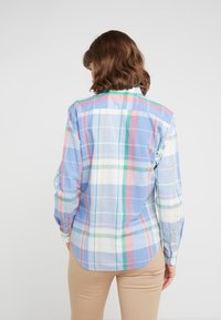 Camicia a quadri multicolore con tonalità di blu, rosa, verde e bianco; maniche lunghe, polsini bottonati e orlo curvo. Tessuto di cotone leggero.