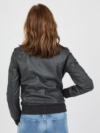 Svart läderjacka med ribbade ärmslut och nederkant, med en figursydd design och slät yta, sedd bakifrån. Informella denimjeans syns.