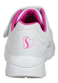 Sneaker bianco con una fodera in rete rosa e dettagli in rosa. Presenta una chiusura in velcro, una texture perforata e un logo a forma di cuore rosa sul tallone.