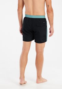 Zwarte zwemshorts met elastische turquoise tailleband, achterzak en zijaccent in kleur. Lichtgewicht stof, knielang ontwerp.