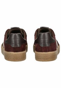 Zapatillas burdeos con parte superior de tela texturizada, acentos de cuero marrón y suela de goma texturizada. Presentan una pestaña en el talón para facilitar su uso.