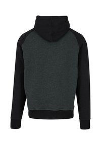Sweat à capuche avec une capuche et des manches noires, présentant un corps gris foncé. Fabriqué en un tissu doux et texturé avec des poignets côtelés.