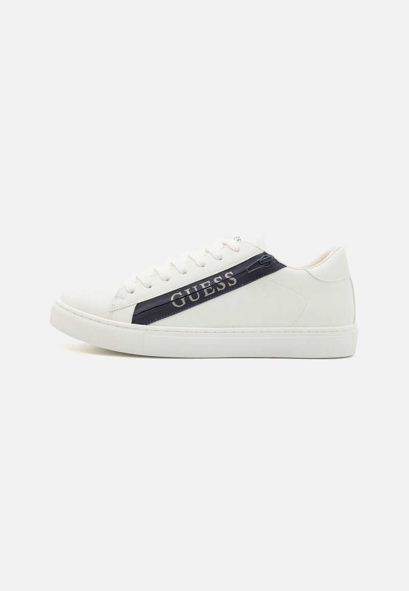 Sneaker bianche con finitura in pelle liscia, dotate di una striscia blu navy e branding "GUESS". Punta rotonda, suola piatta e design con lacci.