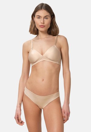 Bralette nue avec bonnets souples et bretelles fines réglables. Culottes taille basse assorties avec une texture lisse et une conception sans coutures.
