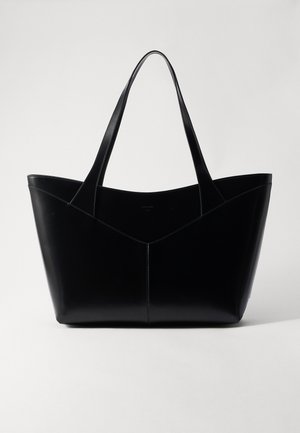 Zwarte leren tote bag met een gestructureerde vorm, voorzien van twee lange handvatten en een V-vormige naaddetail aan de voorkant. Gladde textuur.