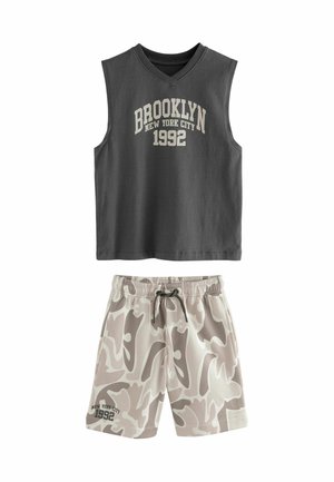 Grijs mouwloos topje met de tekst "BROOKLYN NEW YORK CITY 1992", gecombineerd met beige camouflage shorts met een elastische tailleband en trekkoord.