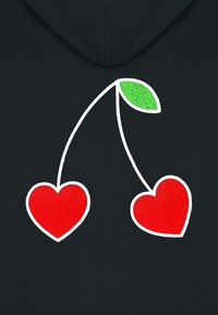 Fekete szövet grafikus dizájnnal, amelyen két piros szív alak található, fehér vonalakkal összekötve, zöld levéllel a tetején.