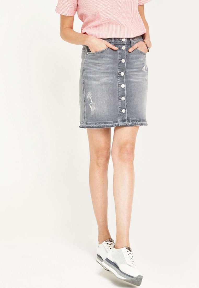Gonna in denim, grigia chiara con bottoni frontali, dettagli delle tasche e aree scolorite. Lunga fino al ginocchio con orlo leggermente sfrangiato.
