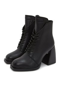 Sorte læder ankle boots med firkantet tå, høj blokhæle og snørebånd foran. Glat tekstur med et struktureret design og minimal udsmykning.