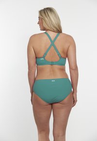 Zeleni bikini set z dizajnom z navzkrižno zaledje in nastavljivimi naramnicami, izdelan iz gladkega materiala. Spodnji del je klasično srednje visok.
