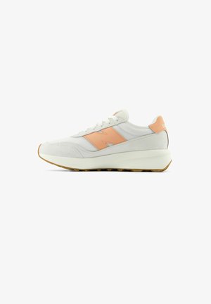 Light gray sneaker made of textile and suede, featuring a peach accent on the side, chunky white sole, and textured laces.