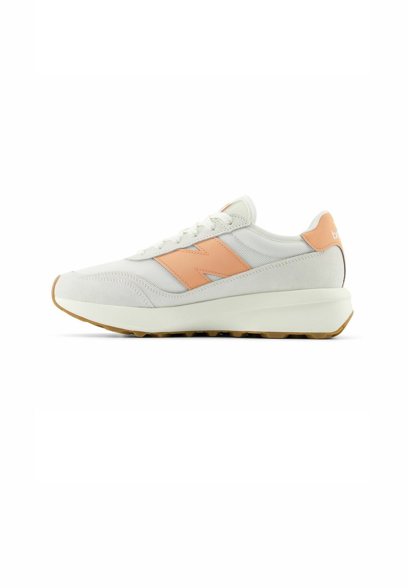 Sneaker grigio chiaro realizzato in tessuto e suede, con un accento pesca sul lato, suola bianca chunky e lacci testurizzati.