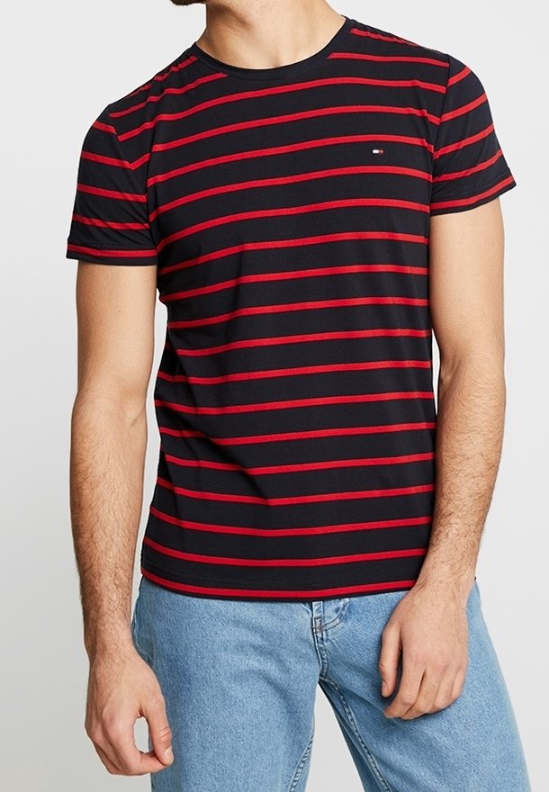 Camiseta negra con rayas rojas horizontales y un pequeño logo en el pecho. Cuello redondo y mangas cortas. Tejido de mezcla de algodón.