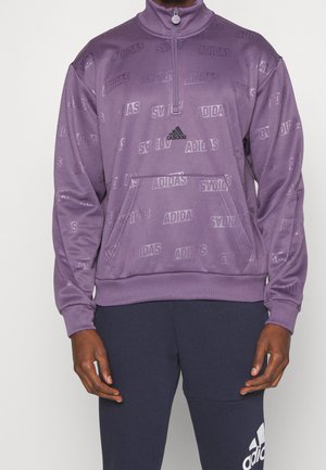 Fialová mikina se čtvrtzipem, s jemným vyraženým vzorem loga Adidas, žebrovanými manžetami a klokankovou kapsou; doplněná tmavě modrými kalhotami.