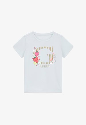 T-shirt blanc à manches courtes avec un logo "G" doré scintillant, décoré de fraises, de fleurs blanches, de petits cœurs rouges et du texte "GUESS Los Angeles".