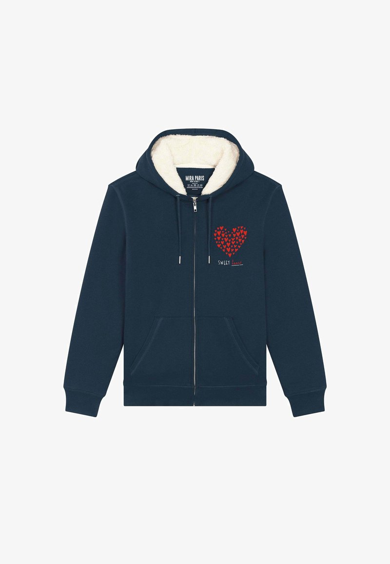 Granatowa bluza z kapturem, zapinana na zamek, z wyściółką z sherpy. Posiada czerwony wzór serca składający się z mniejszych serc oraz napis "SWEET". Dwie przednie kieszenie.