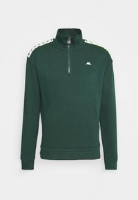 Sweat-shirt en polaire vert avec fermeture éclair quart, équipé d'une poche avant, présentant des accents de marque blancs et jaunes sur les épaules.