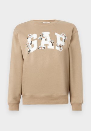 Sweatshirt beige avec des lettres blanches "GAP" décorées de motifs floraux blancs et orange sur la poitrine, manches longues, poignet et ourlet côtelés.
