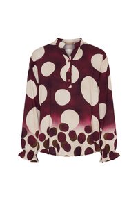 Blus med långa ärmar i bordeaux och krämfärgade stora prickar, bruna mindre prickar nära fållen, knappad krage och volang i ärmsluten.