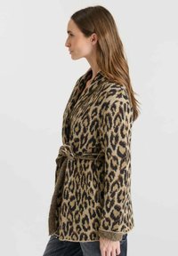 Cardigan de estampado de leopardo en material suave, con un diseño de cinturón, mangas largas y cuello chal. Los colores incluyen marrón claro, negro y marrón.