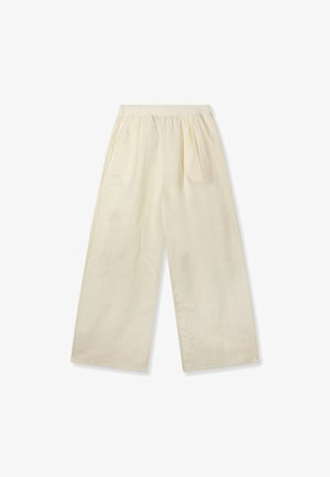 Pantalones de pierna ancha de color crema, de corte holgado, con cintura elástica y pliegues laterales, mostrados extendidos sobre un fondo blanco.