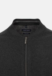 Mörkgrå zip-up cardigan med ribbad krage, tillverkad av Pima-bomull. Har en kontrasterande mönstrad insida och en metalldragkedja.