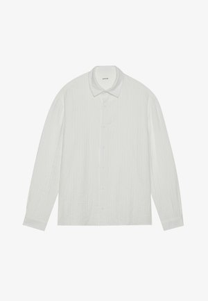 Baltas garām piedurknēm krekls ar teksturētu apdari, klasisku apkakli un pogu priekšpusi. Iespējas ietver vienkāršas pogas un piepogājamās piedurknes.