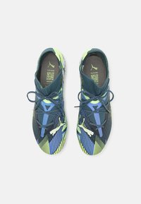 Scarpe sportive con una tomaia in rete multicolore blu scuro e giallo neon, dotate di un cinturino e suola testurizzata per una migliore aderenza.