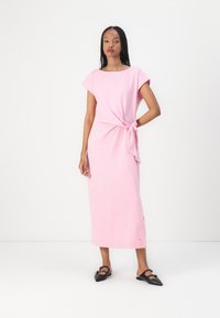 Rosa midi-kjole i lett stoff, med korte ermer, en sideknute-detalj, og en rett snitt med en splitt i bunnen.