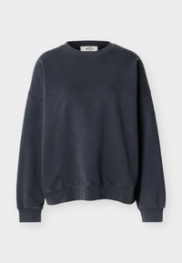 Sweat-shirt gris foncé à manches longues avec col rond, poignets et ourlet côtelés, arborant un logo discret en relief sur la poitrine.