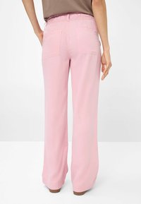 Lichtroze wijde pantalon met een relaxte pasvorm, elastische tailleband en twee achterzakken. Zacht, lichtgewicht stof met een gladde textuur.