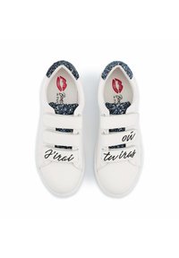 Des baskets blanches avec trois sangles Velcro, des accents bleus pailletés au talon, et le texte noir "J'irai où tu iras" de chaque côté.