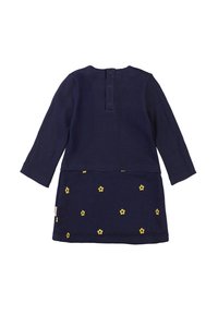 Abito a maniche lunghe di colore blu scuro con un top a coste e un sovrapposto con disegni di fiori gialli, chiusura con bottoni sul retro, morbido texture di cotone.