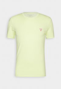 Světlounce žluté bavlněné tričko s kulatým výstřihem a krátkými rukávy. Na levé hrudi se nachází malé červené trojúhelníkové logo.