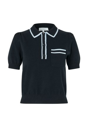 Polo en maille noir à manches courtes avec bordure blanche sur le col, la patte de boutonnage et la poche poitrine. Trois boutons noirs sur le devant.