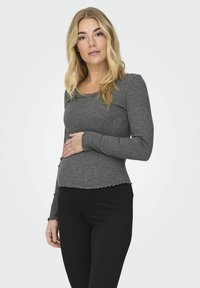 Sivi longsleeve rebrasti top s o�štrim izrezom i rubom, u kombinaciji s crnim rebrastim hlačama, ističući teksturu i prilagođenu siluetu.