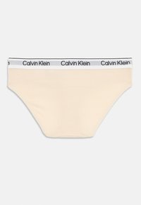 Beige pamut alsónadrág fekete-fehér logós derékkal. A dizájn sima textúrával és standard bikini szabással rendelkezik.