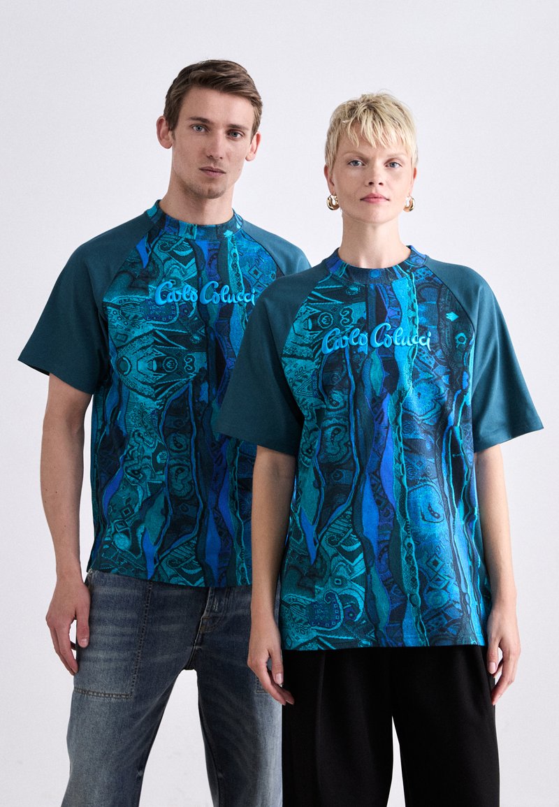 Grafische T-Shirts in Türkis mit abstrakten blauen Mustern. Mit kurzen Ärmeln und einem runden Halsausschnitt. Zeigt den Markennamen auf der Vorderseite.