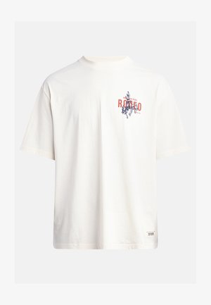 Tricou din bumbac crem, cu mâneci scurte și decolteu rotund. Prezintă un print grafic în nuanțe de albastru și roșu, cu text și un motiv.