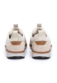 Beige strukturierte Schuhe mit weichen Wildlederakzenten, runder Form, Zuglasche und Gummisohlen; entworfen für einfachen Tragekomfort.