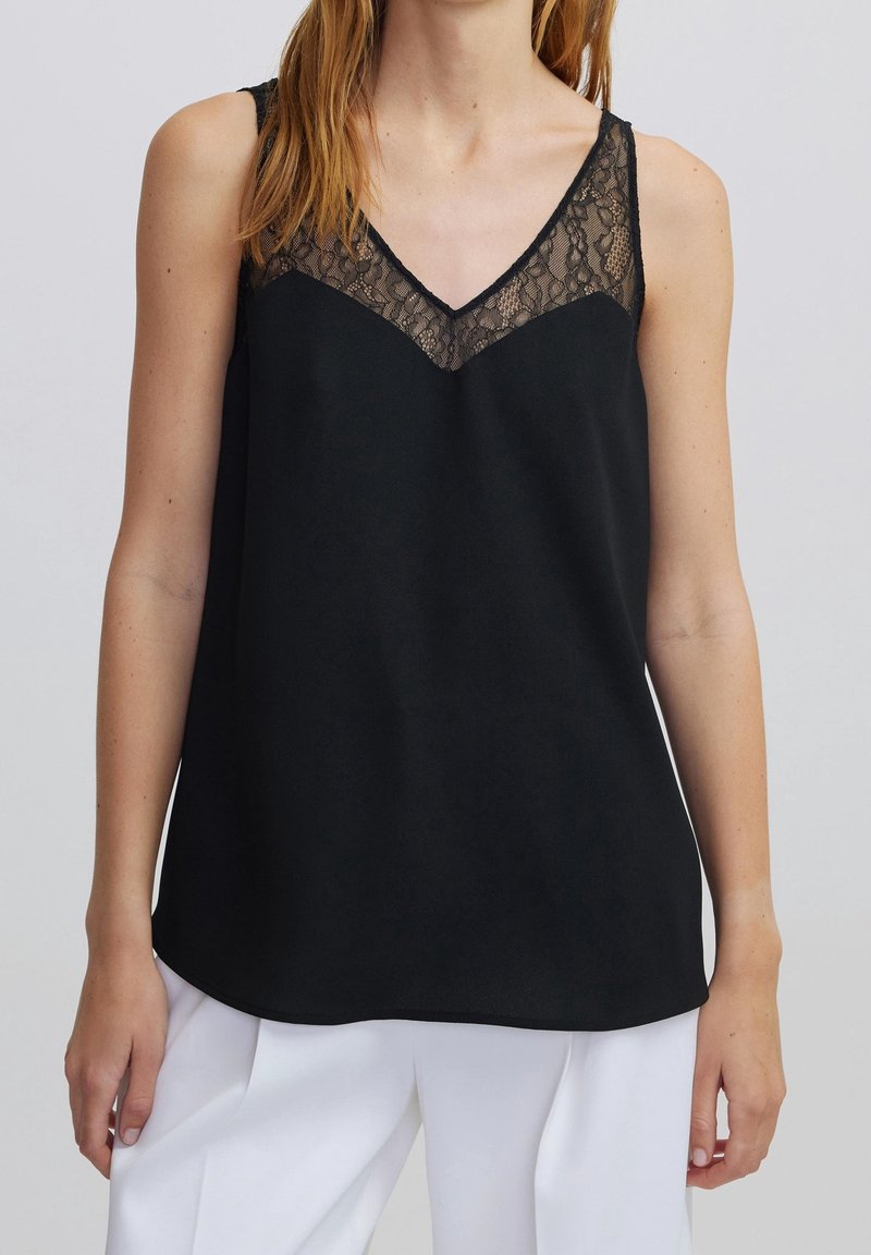 Black sleeveless top with a V-neckline, featuring a lace accent across the bust. Smooth fabric, loose fit, and rounded hem.