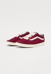 Adidași roșii din suede cu șireturi și accente albe. Design clasic low-top cu dungi laterale și călcâi căptușit.