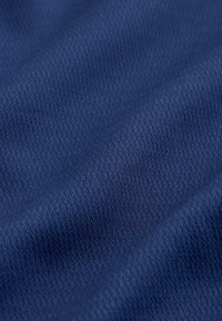 Tessuto blu navy strutturato con un motivo di piccole linee diagonali; la texture liscia e la leggera lucentezza conferiscono profondità al materiale.
