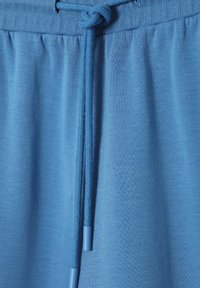 Helle blaue Sweatshirt-Stoff mit strukturiertem Finish, ausgestattet mit einer Kordelzug-Verschluss mit passenden blauen Enden und einem gerippten Taillenbund.