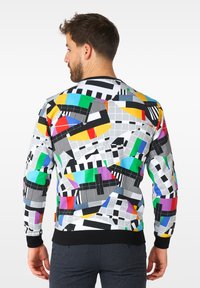 Kolorowy sweatshirt z geometrycznym wzorem, zawierającym różne kształty w kolorach czarnym, białym, żółtym, czerwonym, zielonym, niebieskim i fioletowym. Czarny ściągacz na rękawach i u dołu.
