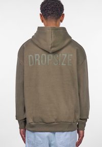Olivengrøn hættejakke med et stort, lys gr�åt "DROPSIZE" print på ryggen. Har snoretræk i hætten samt ribbede manchetter og kant.