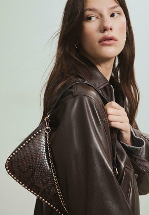 Borsa a forma triangolare in finta pelle di serpente marrone scuro con borchie metalliche lungo il bordo, dotata di una tracolla a catena e superfici testurizzate.