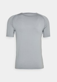 Camisa gris de manga corta con una textura suave y un diseño ajustado. Presenta sutiles acentos a rayas en los hombros y un cuello redondo.