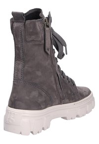 Botte à lacets en daim gris foncé avec fermeture éclair latérale et semelle épaisse blanche et épaisse, vue de dos et de côté sur fond blanc.